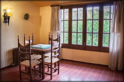 a dining room with a table and chairs and a window at Hostal l'Avet Blau in Santa Fe de Montseny