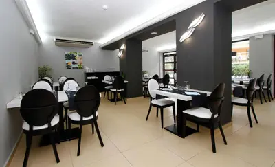 a restaurant with black and white chairs and tables at Summer Hotel in Calella