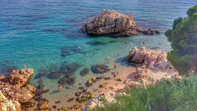 a group of people swimming in the water at a beach at Summer Hotel in Calella