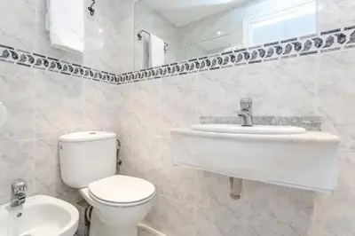 a white bathroom with a toilet and a sink at Centric Apartments Paseo de Gracia in Barcelona