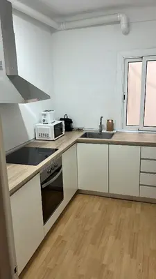a kitchen with white cabinets and a sink and a microwave at Centric Apartments Paseo de Gracia in Barcelona