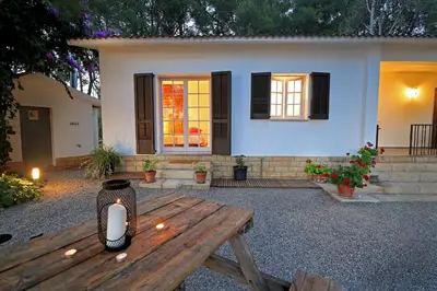 a candle sitting on a wooden table in front of a house at Casa Rural Els Pins in Sant Marçal