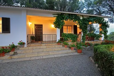 a white house with stairs and an entry way at Casa Rural Els Pins in Sant Marçal