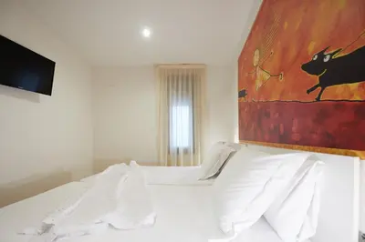 a bedroom with a bed with a painting on the wall at Apart-Suites Hostemplo in Barcelona
