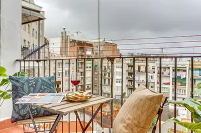 a table with a glass of wine on a balcony at Sweett - Aragon in Barcelona