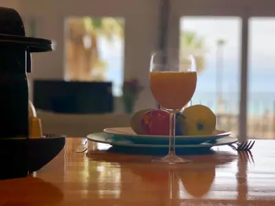 a glass of wine sitting on a table with a plate of fruit at Vilamarlux II in Vilassar de Mar
