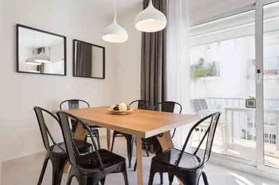 a dining room with a wooden table and chairs at Sitges Group Calm Beach in Sitges