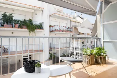 a balcony with chairs and plants on a building at Sitges Group Calm Beach in Sitges