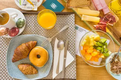 a table with a plate of food and a bowl of fruit at Cosmopolitan Boutique Rambla in Barcelona
