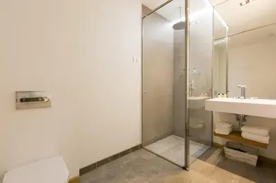 a bathroom with a glass shower and a sink at Cosmopolitan Boutique Rambla in Barcelona