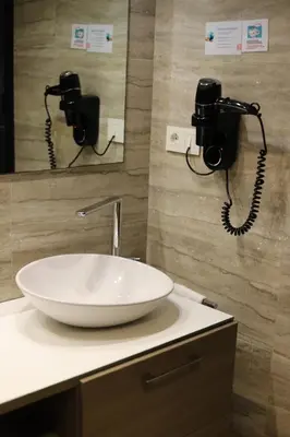 a bathroom with a white sink and two phones at New Hotel Colon in Mataró