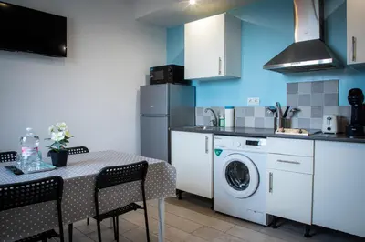 a kitchen with a washing machine and a table with chairs at Apartamentos Comfort Calella in Calella