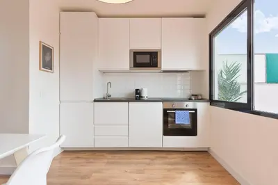 a kitchen with white cabinets and a window at Urban Chill Apartments by Olala Homes in Hospitalet de Llobregat