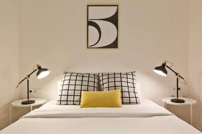a bedroom with two lamps and a bed with a yellow pillow at Urban Chill Apartments by Olala Homes in Hospitalet de Llobregat