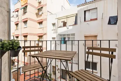 a balcony with a wooden table and two benches at Urban Chill Apartments by Olala Homes in Hospitalet de Llobregat