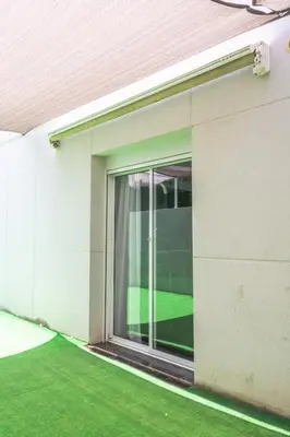 a sliding glass door of a building with green grass at Luxurious Villa Marly II piscina climatizada in Castelldefels