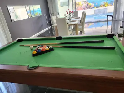 a pool table with three balls and cuesticks on it at Luxurious Villa Marly II piscina climatizada in Castelldefels