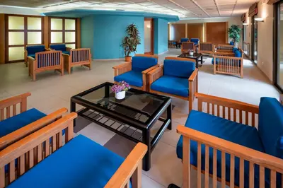 a waiting room with blue chairs and a table at Hotel Sabiote in Pineda de Mar