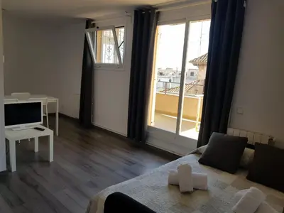 a room with a bed and a television and a window at Hostal Termes in Sitges