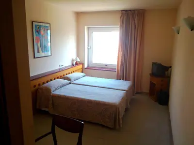 a hotel room with a bed and a window at Hotel Montmeló in Montmeló