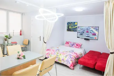 a bedroom with a bed and a table and chairs at Camp Nou, Europa Fira - modern two-bedroom apartment with heating in Hospitalet de Llobregat