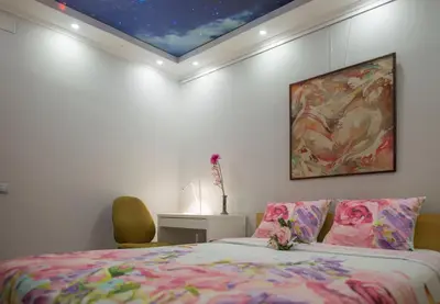 a bedroom with a bed with a painting on the wall at Camp Nou, Europa Fira - modern two-bedroom apartment with heating in Hospitalet de Llobregat