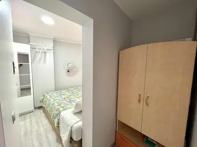 a small bedroom with a bed and a closet at Camp Nou, Europa Fira - modern two-bedroom apartment with heating in Hospitalet de Llobregat