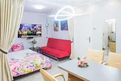 a bedroom with a bed and a red couch at Camp Nou, Europa Fira - modern two-bedroom apartment with heating in Hospitalet de Llobregat