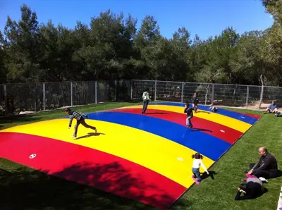a group of children playing on a large trampoline at Camping Vilanova Park in Vilanova i la Geltrú