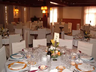 a dining room with white tables and white chairs at Camping Vilanova Park in Vilanova i la Geltrú