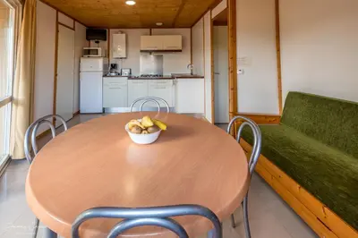 a table and chairs with a bowl of fruit on it at Camping Vilanova Park in Vilanova i la Geltrú