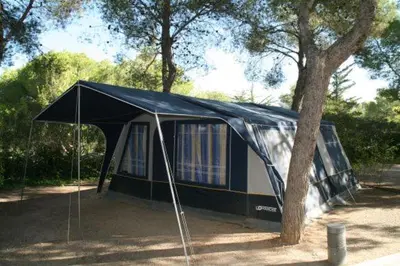 a tent is set up next to a tree at Camping Vilanova Park in Vilanova i la Geltrú
