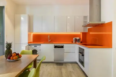 a kitchen with white cabinets and an orange counter top at Cosmo Apartments Marina – Auditori in Barcelona