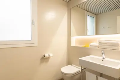 a bathroom with a sink and a toilet and a mirror at Cosmo Apartments Marina – Auditori in Barcelona