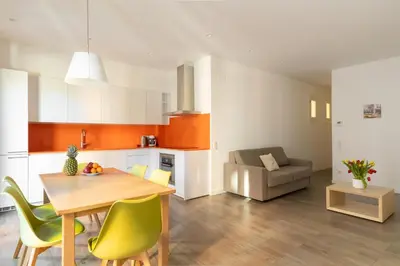 a kitchen and living room with a table and chairs at Cosmo Apartments Marina – Auditori in Barcelona