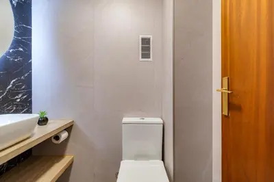 a bathroom with a white toilet and a sink at Spacious 4 Bedroom Apartment Fira BCN & Camp Nou in Barcelona