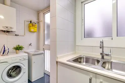 a kitchen with a sink and a washing machine at Spacious 4 Bedroom Apartment Fira BCN & Camp Nou in Barcelona