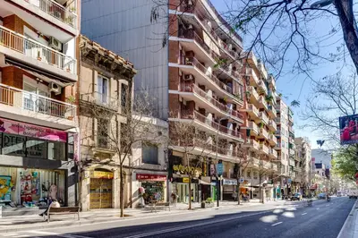 an empty city street with tall buildings on the side at Spacious 4 Bedroom Apartment Fira BCN & Camp Nou in Barcelona