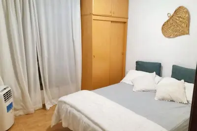 a bedroom with a bed with white sheets and pillows at Modern apartment in Calella - 50 sqm - Comfortable balcony in Calella