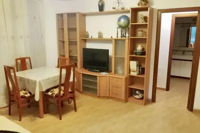 a living room with a table and a television at Modern apartment in Calella - 50 sqm - Comfortable balcony in Calella
