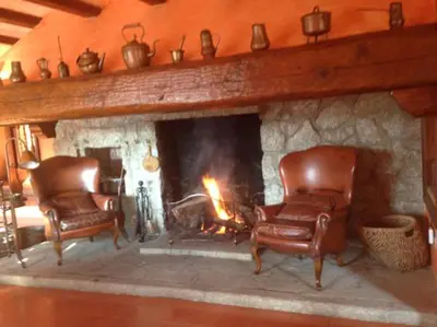 two chairs sitting in front of a fireplace at Masia Vista Hermosa in Vallromanas
