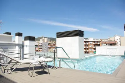 a balcony with a swimming pool on top of a building at 08028 Apartments in Barcelona