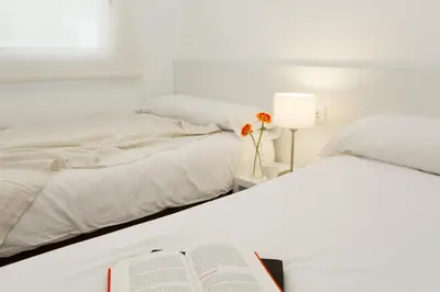 a bedroom with two beds and a book on a bed at 08028 Apartments in Barcelona