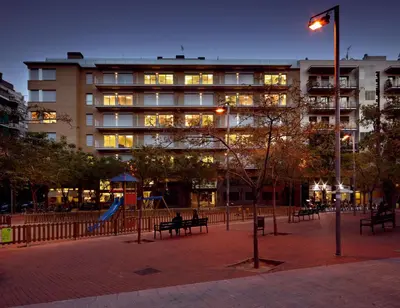 a large building with a playground in front of it at 08028 Apartments in Barcelona