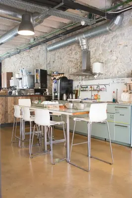 a kitchen with a table and white chairs at Ten To Go Hostel in Barcelona
