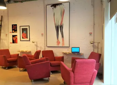 a waiting room with red chairs and a laptop at Ten To Go Hostel in Barcelona