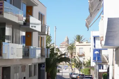a city street with buildings and palm trees at Matilda Home on the Beach in Sitges