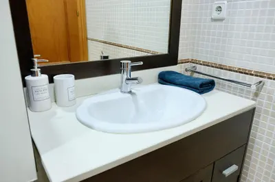a bathroom with a white sink and a mirror at Apartment Port Forum in Barcelona