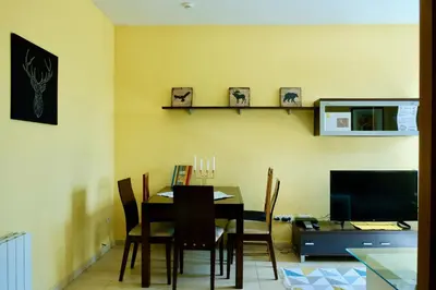 a dining room with a table and chairs and a television at Apartment Port Forum in Barcelona