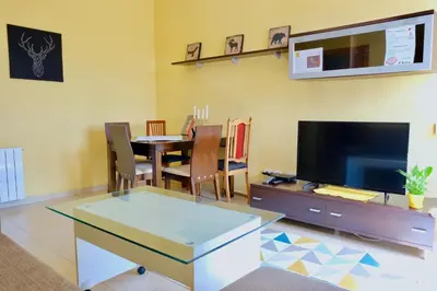 a living room with a tv and a table with chairs at Apartment Port Forum in Barcelona